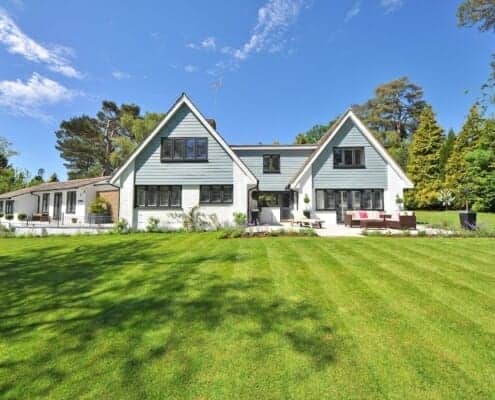 A house with a big beautiful green lawn maintained by a lawncare professional