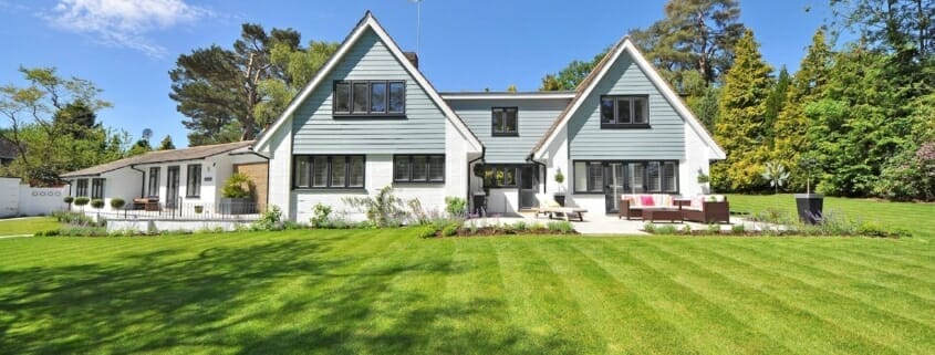 A house with a big beautiful green lawn maintained by a lawncare professional